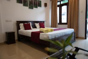 um quarto com uma cama com almofadas vermelhas e amarelas em Weligama Watergate em Weligama