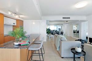 a kitchen and living room with a counter and chairs at Chevron Renaissance - Self Contained Apartments - Wow Stay in Gold Coast