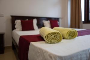 Dos camas en una habitación de hotel con toallas. en Weligama Watergate en Weligama