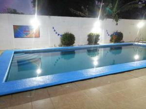 una piscina por la noche con luces alrededor en alberca Blass en Coatzacoalcos