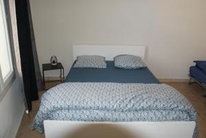 - une chambre avec un lit doté d'une couette et d'oreillers bleus dans l'établissement mas, à Aniane
