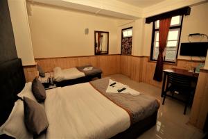 a hotel room with two beds and a desk at The Griffon's Nest in Gangtok