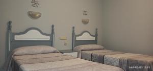 Cette chambre comprend 2 lits et 2 miroirs. dans l'établissement Hostal San Antonio, à Iscar