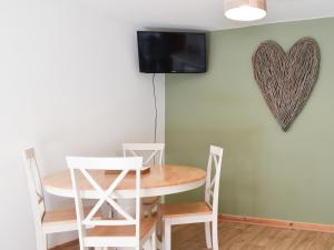 The Hayloft - Uk43352 في Wortley: طاولة وكراسي في غرفة الطعام مع قلب على الحائط