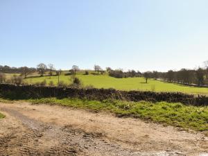 a dirt road with a green field in the background at The Hayloft - Uk43352 in Wortley