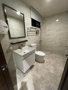 W łazience znajduje się umywalka, toaleta i lustro. w obiekcie 玉井拱月民宿 w mieście Yujing