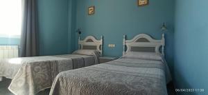 two beds in a room with blue walls at Hostal San Antonio in Iscar +22 photos