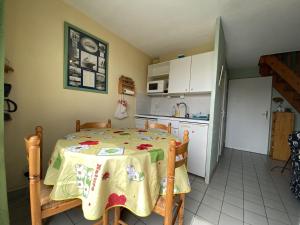 een keuken met een tafel en een keuken met een koelkast bij Appartement Erdeven, 3 pièces, 4 personnes - FR-1-397-68 in Erdeven