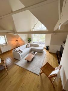 een woonkamer met een witte bank en een tafel bij Nuits De Mer in De Haan