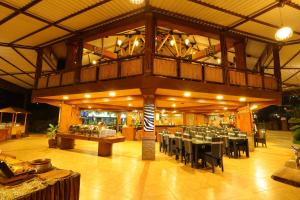 Safari Resort في بونشاك: مطعم بطاولات وكراسي في مبنى