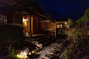 una casa por la noche con escaleras que conducen a un porche en オリーブの宿 澳邸, en Takamatsu