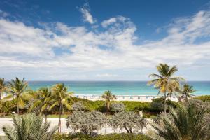 a beach with palm trees and palm trees at Opal Grand Oceanfront Resort & Spa in Delray Beach