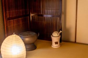 a corner of a room with a toilet and a lamp at オリーブの宿 澳邸 in Takamatsu