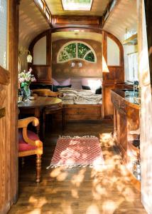 uma sala de comboios com uma cama e uma mesa em historischer Zirkuswagen inmitten der Natur em Fischach
