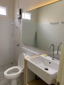 La salle de bains est pourvue de toilettes blanches et d'un lavabo. dans l'établissement W House Ranong1Bedroom villa8/11, à Ranong