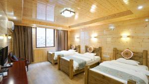 Postel nebo postele na pokoji v ubytování Jiuzhaigou Leisure Inn