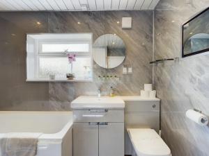 a bathroom with a sink and a mirror at Zoo Cottage in Chester