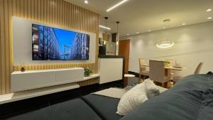 uma sala de estar com uma grande televisão na parede em Condomínio encantador de luxo em Goiânia