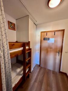 a room with a bunk bed and a door at Hyper Centre Valmeinier 1800 in Valmeinier