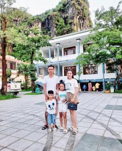 une famille posant une photo devant un bâtiment dans l'établissement Heritage By Night, à Lang Va