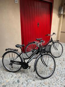 dos bicicletas estacionadas frente a una puerta roja en Casa Mirella, en Lovere