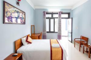 une chambre avec un lit, un bureau et une fenêtre dans l'établissement Heritage By Night, à Phong Nha