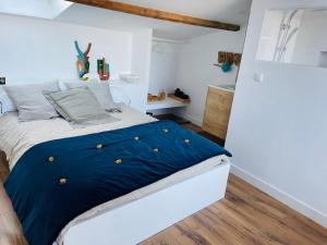 a bedroom with a bed with a blue comforter at Maison de charme de 280m2 avec piscine chauffée … in Luçon