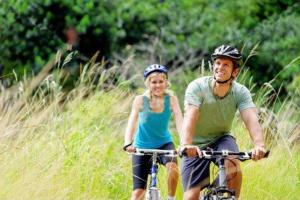 a man and a woman riding bikes in the grass at Hotel Rural La villa Don Quijote in Cuenca