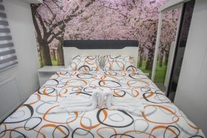 a bedroom with a bed withakura trees in the background at Apartment LUX 2 in Tuzla