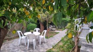 a white table and chairs under a lemon tree at Elpida Lemon Garden House in Limassol