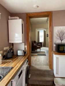 a kitchen with a counter and a door to a living room at Hope Corner in Filey