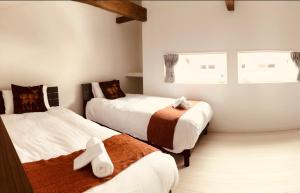 ein Schlafzimmer mit zwei Betten mit Kreuzen in der Unterkunft Neverland Chalet in Hakuba