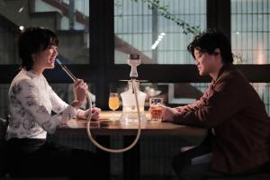 zwei Frauen sitzen an einem Tisch mit Getränken in der Unterkunft UNPLAN Shinjuku in Tokio