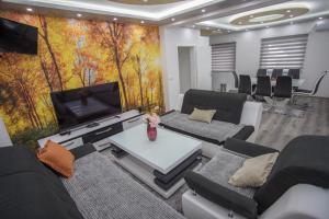 a room with couches and a flat screen tv at Apartment LUX 2 in Tuzla