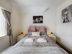 a bedroom with a large bed with pink pillows at Zoo Cottage in Chester