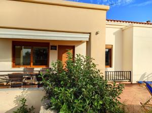 Ein Haus mit einer Terrasse und einem Haus in der Unterkunft Helidonia Villas in Pigi