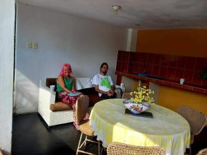 Dos personas sentadas en una sala de estar con una mesa en Villa Hospedaje Chanchan Cultural Lodge, en Trujillo