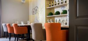 a dining room with a table with orange chairs at Artearia Hotel in Bjelovar
