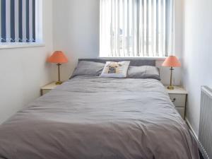 a bedroom with a large bed with two lamps at The Hawthorns in Seaham