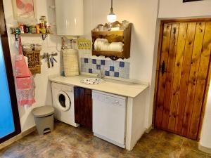 a laundry room with a sink and a washing machine at Casa Tatisita III in Segura de la Sierra +21 photos