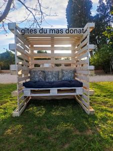un banco de madera sentado en el césped en un campo en gites du mas Donat en Perpiñán
