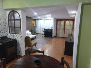 eine Küche und ein Wohnzimmer mit einem Tisch und einem Wohnzimmer in der Unterkunft Casa Martín in Tunuyán