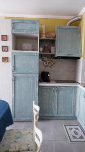 a kitchen with blue cabinets and a table and chairs at Anthic 7 Apartment 3 in Sozopol