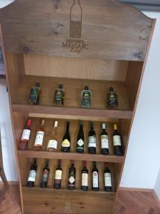 un estante de vino con un montón de botellas de vino en Kuća u selu sa bilijar salom za aktivan odmor, en Mionica