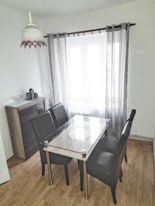 een eetkamer met een glazen tafel en 2 stoelen bij Apartmán Isabel in Děčín