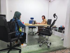 zwei Frauen, die an einem Tisch in einem Büro sitzen in der Unterkunft Digital Nomad House KL Bukit Bintang - Self service shared bathroom apartment in Kuala Lumpur