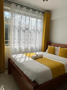 a bedroom with a large bed with a window at Comfortplace 2 bedroom in Kericho