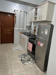 a kitchen with a refrigerator and a stove top oven at Comfortplace 2 bedroom in Kericho