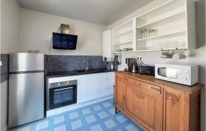 kuchnia z białymi szafkami i lodówką ze stali nierdzewnej w obiekcie Beautiful Apartment In Saint-Dizier w mieście Saint-Dizier +7 zdjęć