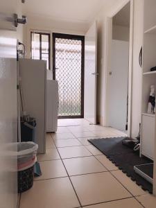 a kitchen with a door and a tile floor at Home Away From Home-(Room1&2) in Gold Coast